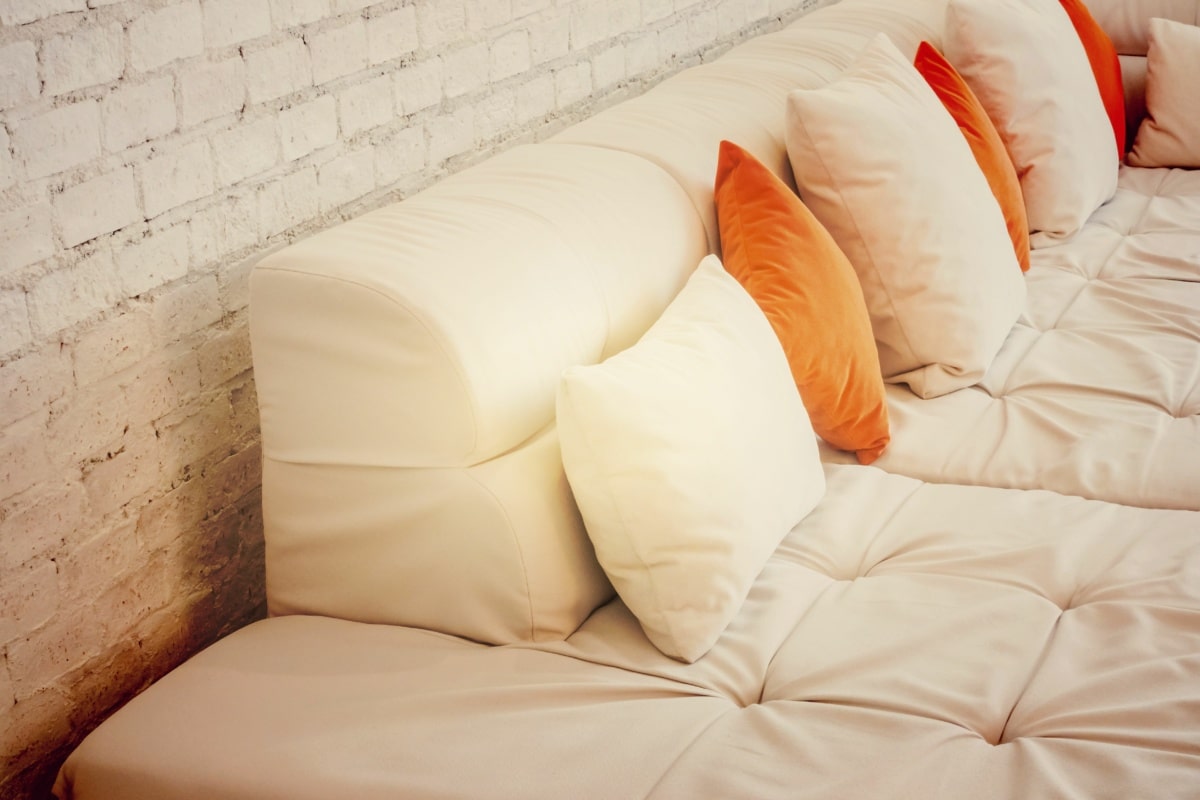 Confortable sofá tapizado con goma espuma y cojines, ilustrando los usos y aplicaciones de la goma espuma en el hogar.